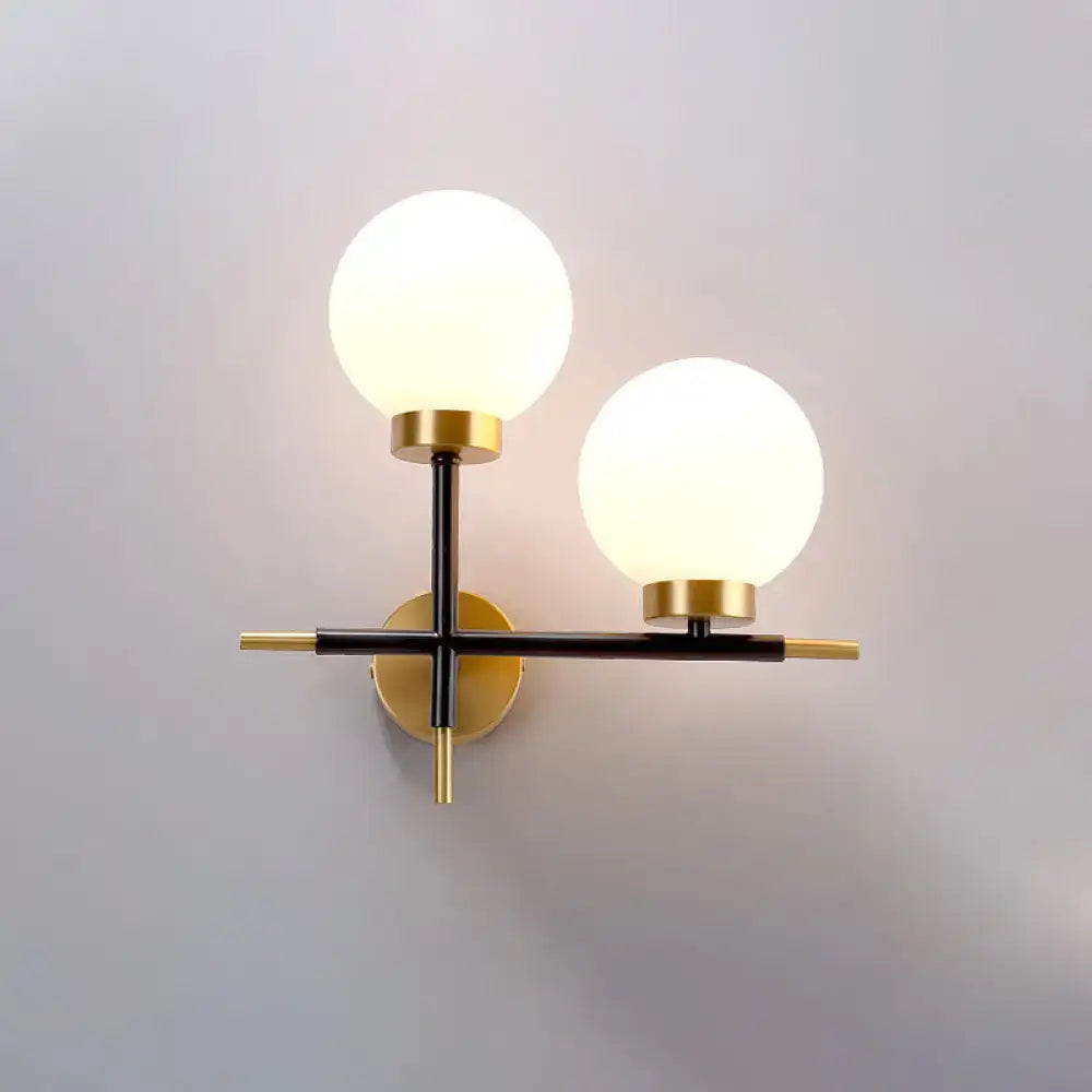 White brass sphere sconce by Decorbites, wall-mounted double-globe lights with black arms on Tampa Home & Garden Store