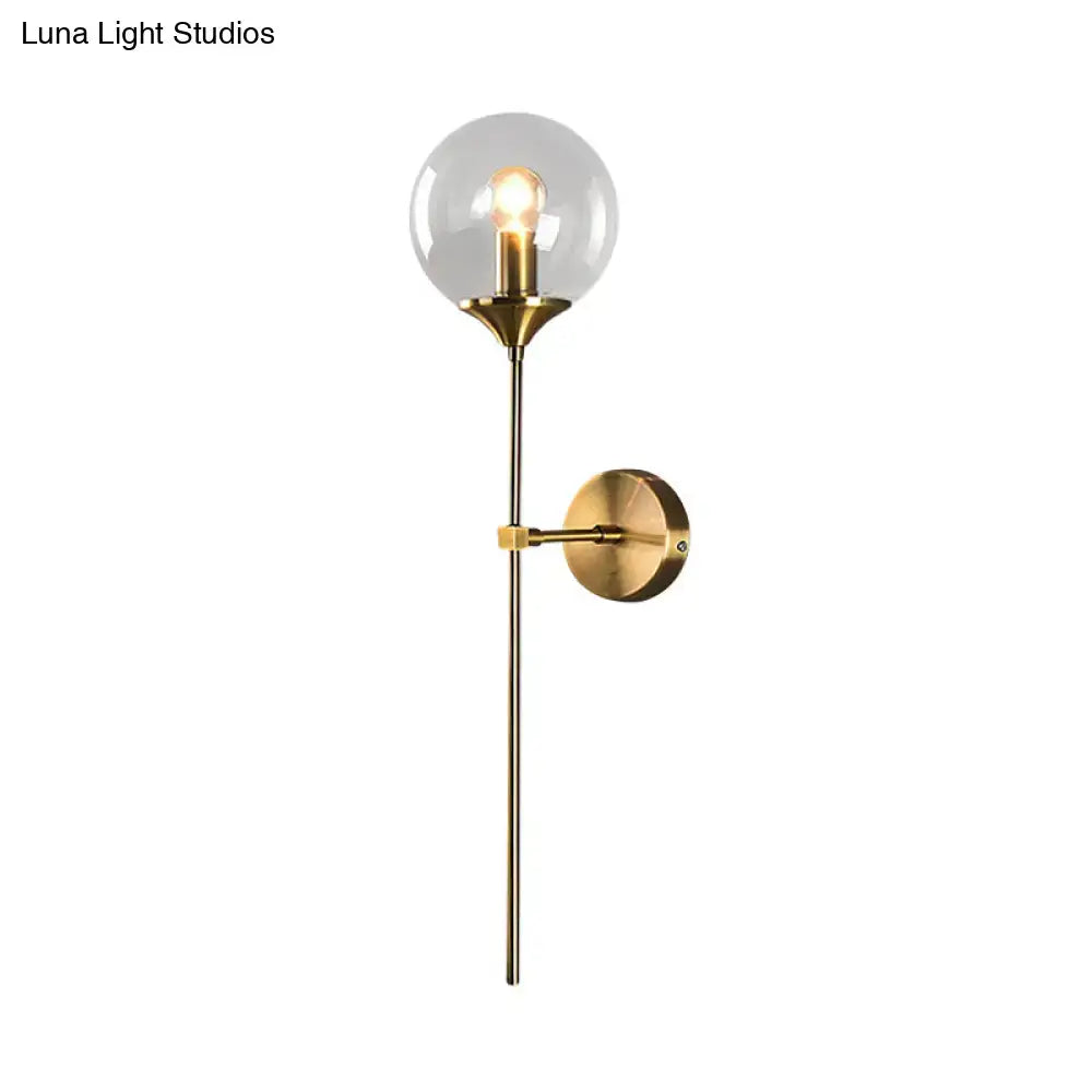 Amber Smoke Glass Wall Sconce with brass finish and glass globe, wall-mounted on Tampa Home & Garden Store