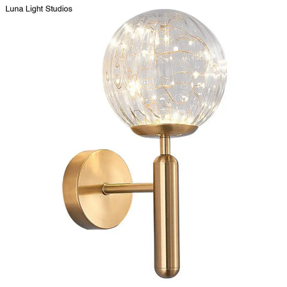 Decorbites black glass wall sconce with brass mount and clear globe with inner string lights on Tampa Home & Garden Store