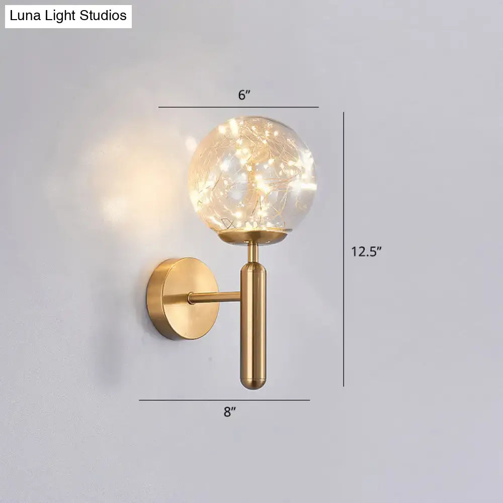Black Glass Wall Sconce with brass mount and glass globe containing string lights on Tampa Home & Garden Store