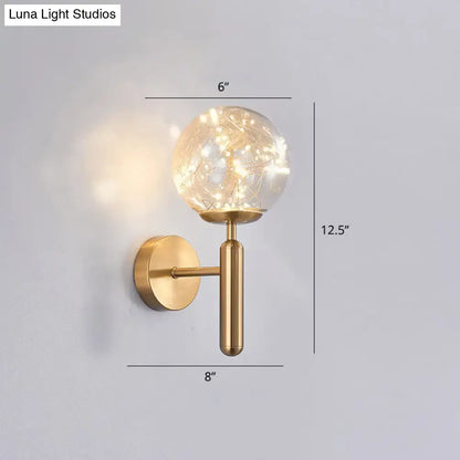 Black Glass Wall Sconce with brass mount and glass globe containing string lights on Tampa Home & Garden Store