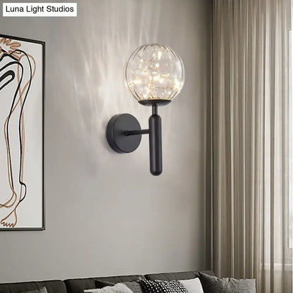 Black glass wall sconce with clear globe and string lights, matte black mount Decorbites on Tampa Home & Garden Store