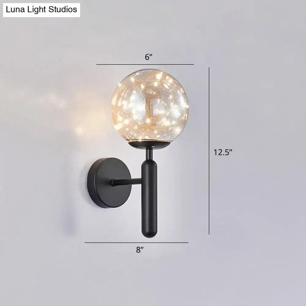 Black glass wall sconce with a 6-inch globe, warm string lights on a metal arm with backplate on Tampa Home & Garden Store