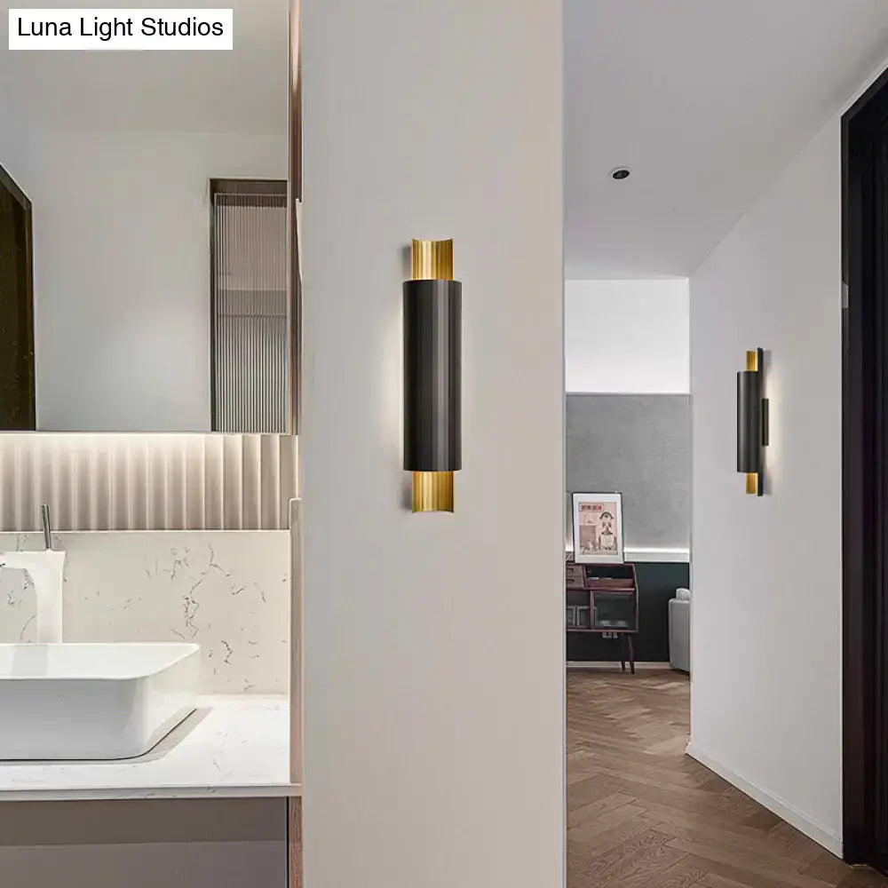 Black Gold Pipe LED Sconce; twin black cylindrical wall lights with gold caps in a white hallway on Tampa Home & Garden Store