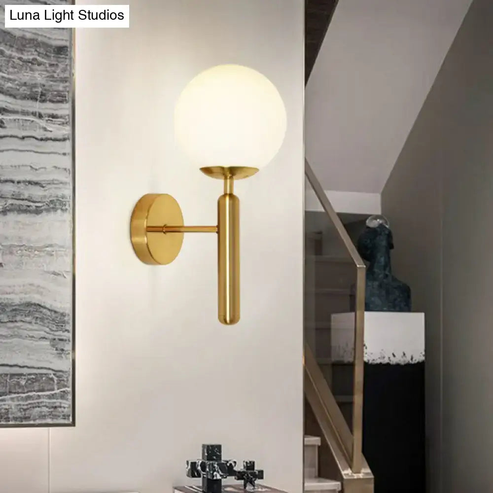 Postmodern brass gold wall sconce with glass globe shade by Decorbites on white wall on Tampa Home & Garden Store