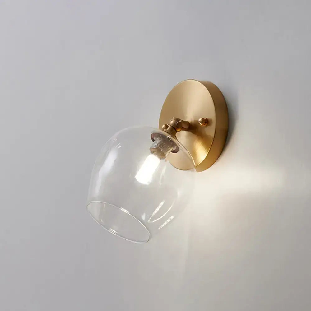 Brass glass wall sconce with clear glass shade and round backplate on Tampa Home & Garden Store