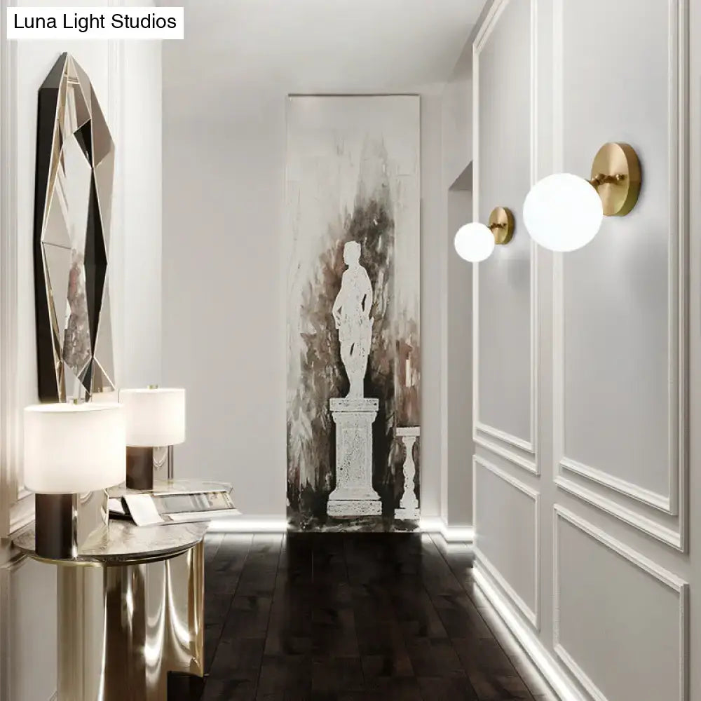 Brass glass wall sconce by Decorbites; globe lights with brass backplates in hallway on Tampa Home & Garden Store