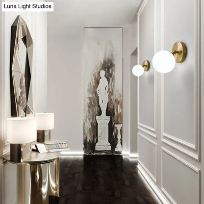 Brass glass wall sconce by Decorbites; globe lights with brass backplates in hallway on Tampa Home & Garden Store