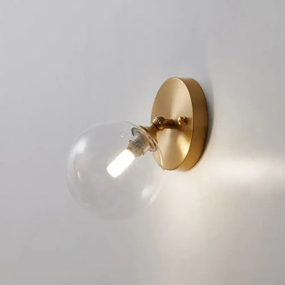 Brass Glass Wall Sconce with clear globe bulb on wall plate on Tampa Home & Garden Store