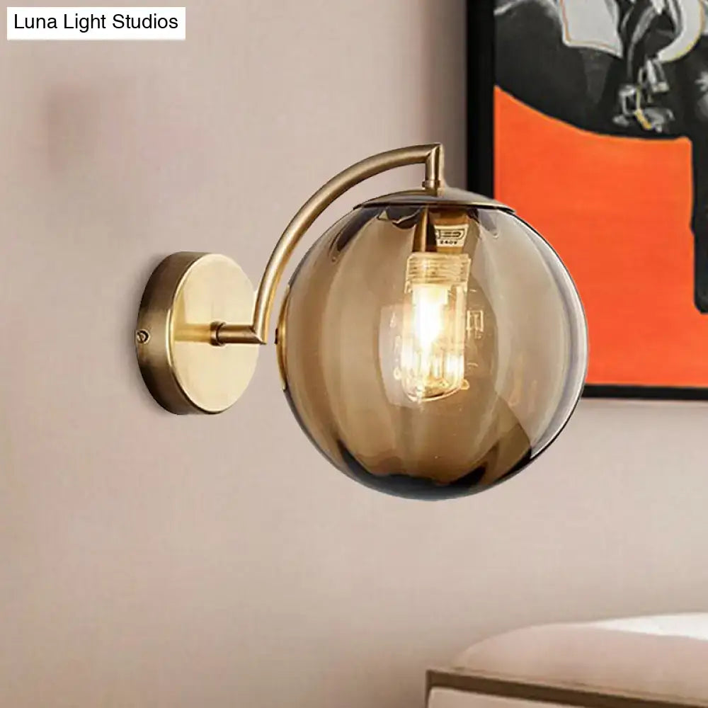 Brass amber glass ball sconce with curved arm and single-light head Decorbites on Tampa Home & Garden Store
