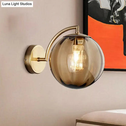 Brass amber glass ball sconce with curved arm and single-light head Decorbites on Tampa Home & Garden Store