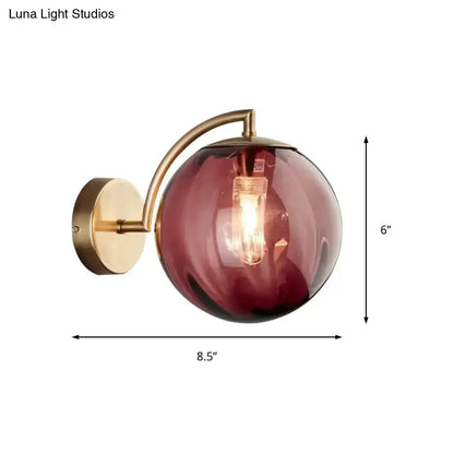 Brass amber ball sconce by Decorbites with curved arm and single-light head, wall mount on Tampa Home & Garden Store