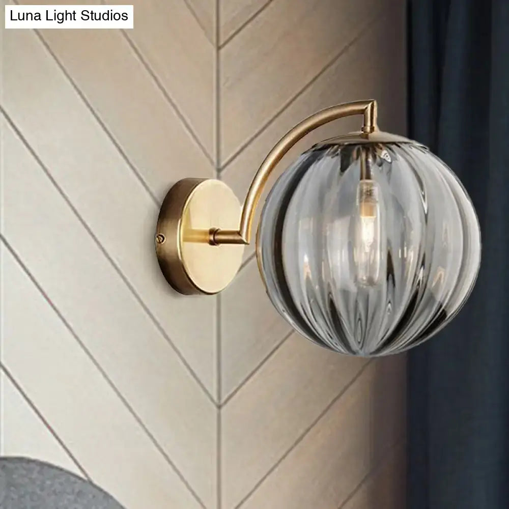 Brass amber glass ball sconce with curved arm, single-light head on Tampa Home & Garden Store
