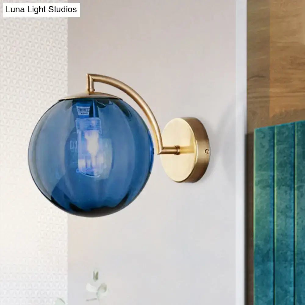 Brass amber ball sconce with blue glass globe and curved brass arm, single-light wall mount on Tampa Home & Garden Store