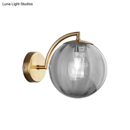 Brass amber ball sconce with curved arm and glass globe, Decorbites on Tampa Home & Garden Store