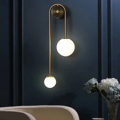 Brass opal glass wall sconce with dual globe lights on curved brass rod Decorbites on Tampa Home & Garden Store