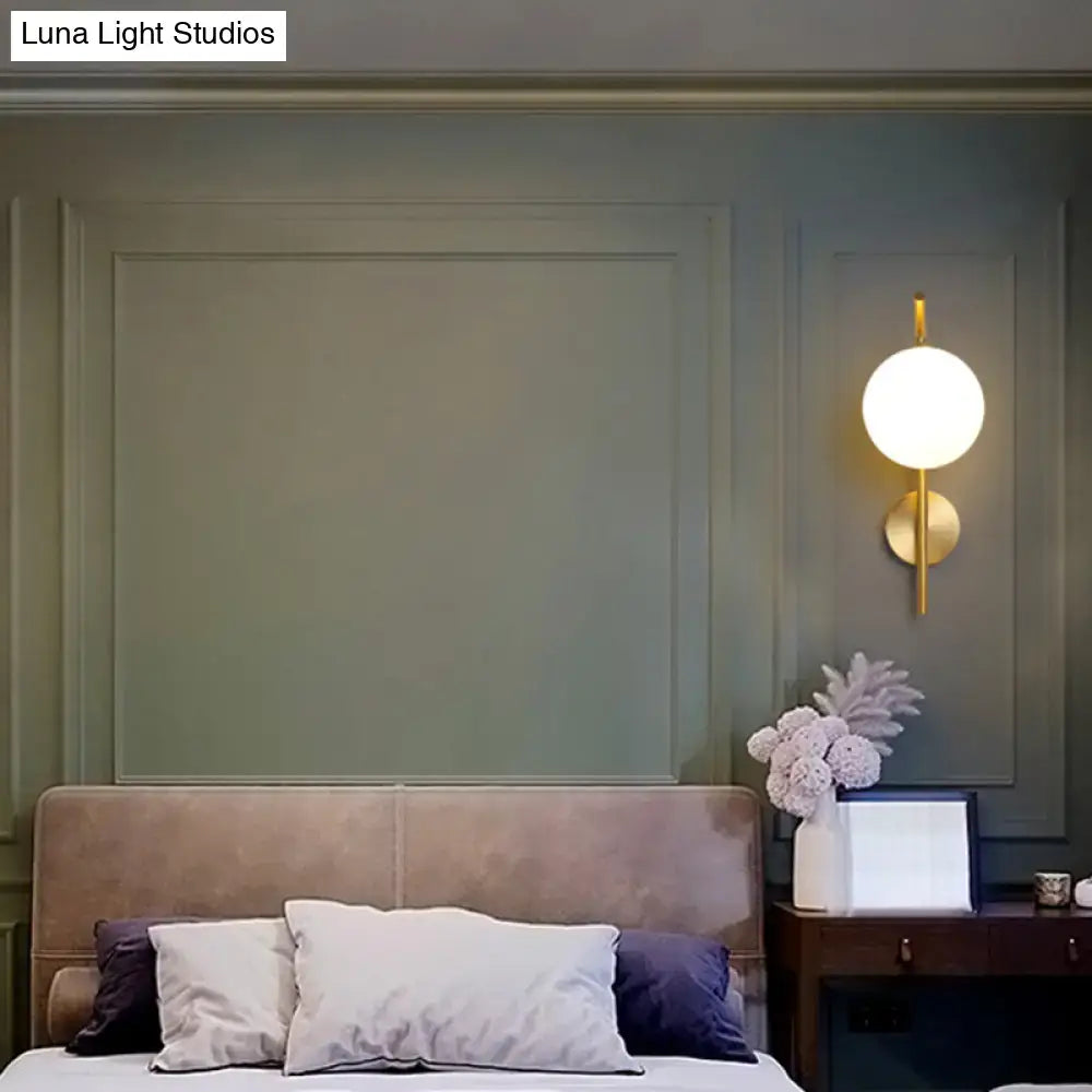 Brass Geometric Glass Sconce with round white globe, wall-mounted bedside lighting on Tampa Home & Garden Store