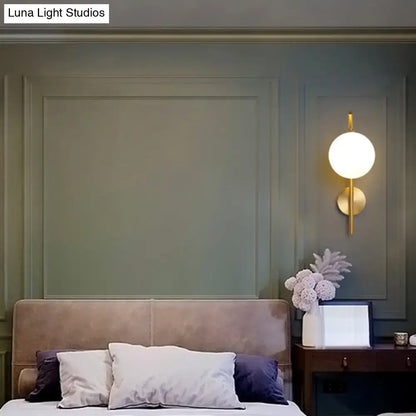 Brass Geometric Glass Sconce with round white globe, wall-mounted bedside lighting on Tampa Home & Garden Store