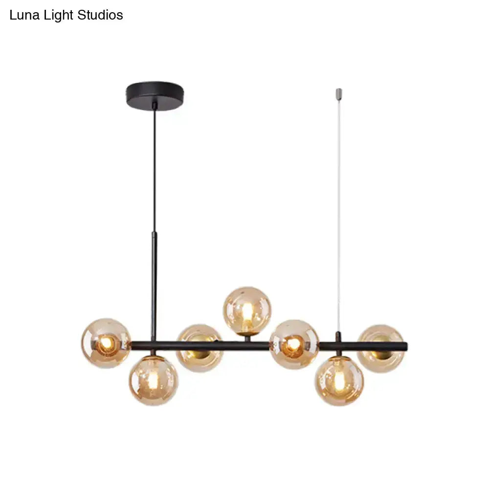 Postmodern glass ball pendant light with brass finish and frosted glass spheres on a black bar on Tampa Home & Garden Store