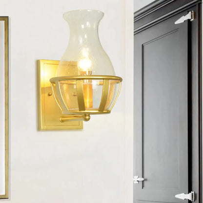 Gold clear glass wall lamp by Decorbites with brass backplate and cage shade on Tampa Home & Garden Store