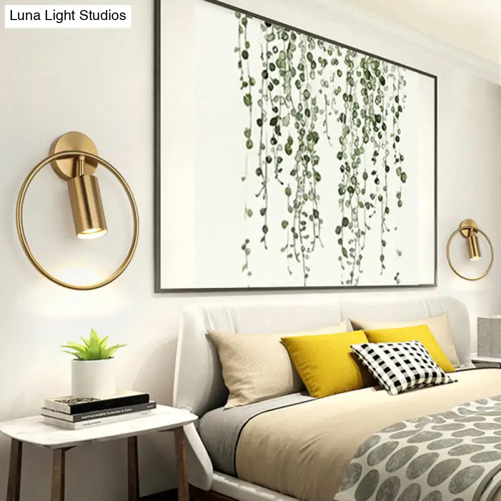 Gold halo ring wall sconce by Decorbites with brass circle and circular light, mounted over bed on Tampa Home & Garden Store