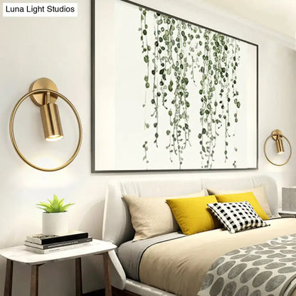Gold halo ring wall sconce by Decorbites with brass circle and circular light, mounted over bed on Tampa Home & Garden Store