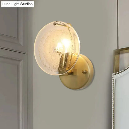 Gold brass wall sconce with round clear glass shade and bubble texture, wall mounted on Tampa Home & Garden Store