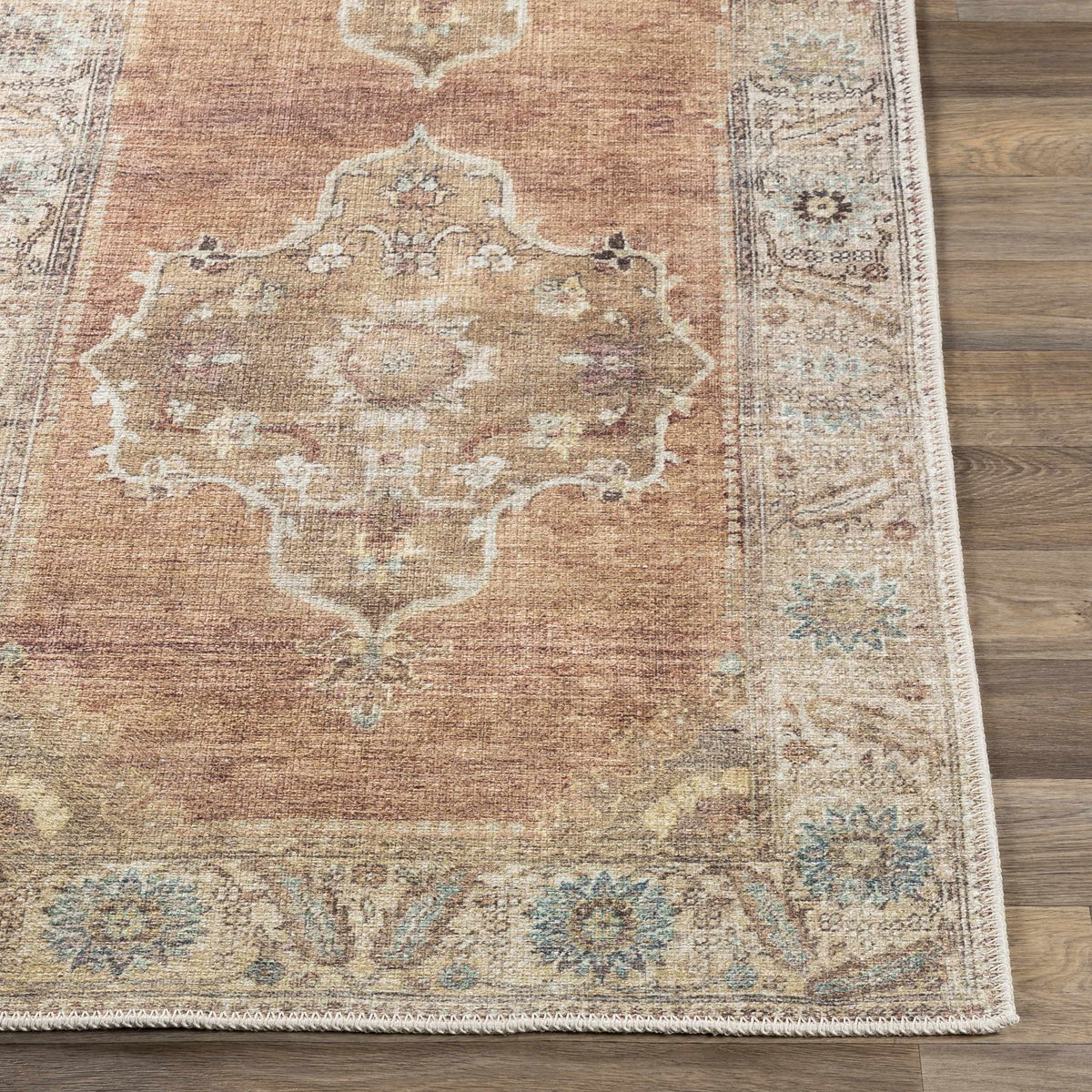 Powhatan Washable Area Rug rust with ornate medallion border by Boutique Rugs on wood floor on Tampa Home & Garden Store