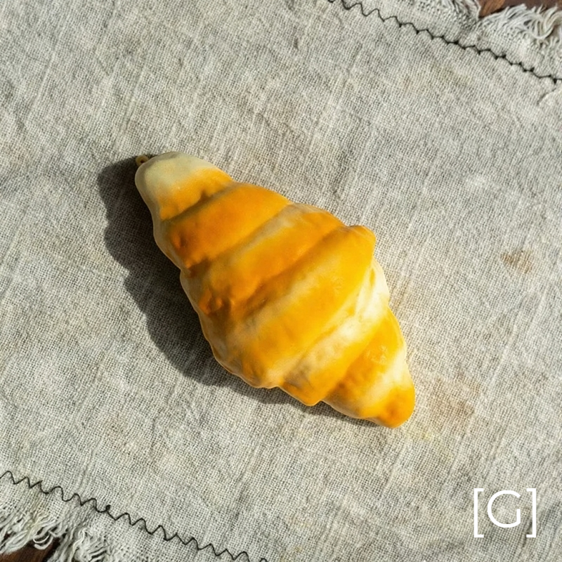 Artificial croissant pastry display prop by RusticReach in golden yellow on linen backdrop on Tampa Home & Garden Store