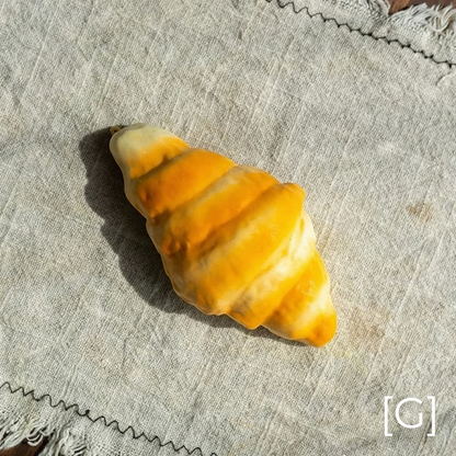 Artificial croissant pastry display prop by RusticReach in golden yellow on linen backdrop on Tampa Home & Garden Store