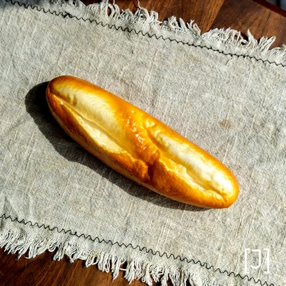 Artificial bread loaf display prop by RusticReach on linen cloth with fringe on Tampa Home & Garden Store