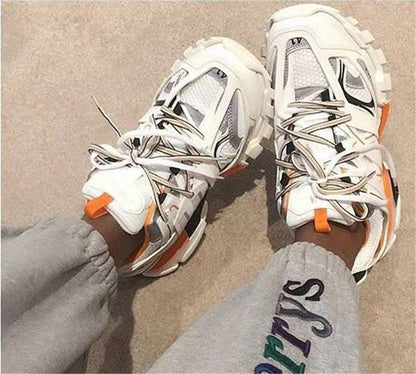 Pair of white Stevvex breathable mesh sneakers with orange accents on sand on Tampa Home & Garden Store