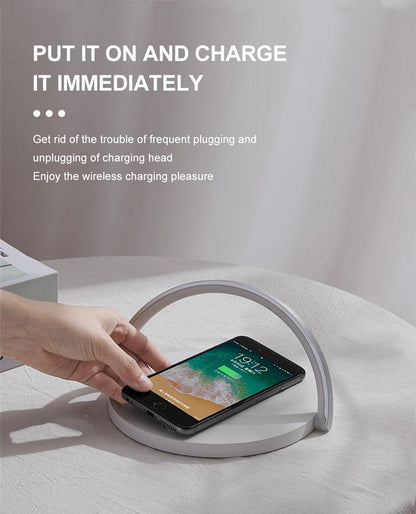 Wireless charger LED night light lamp from Stevvex with gray arc and phone charging on base on Tampa Home & Garden Store