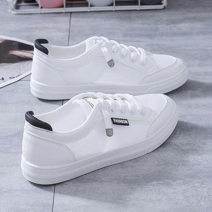 Pair of women's white mesh casual sneakers with lace-up and black heel tab on Tampa Home & Garden Store