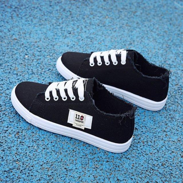 Women’s black canvas sneakers with white laces and sole, frayed edges, side patch pair on Tampa Home & Garden Store