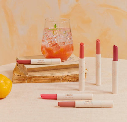 mude Drizzle Bomb lip stains Seoulia, 6 colors in white tubes on a beige table with lemon on Tampa Home & Garden Store