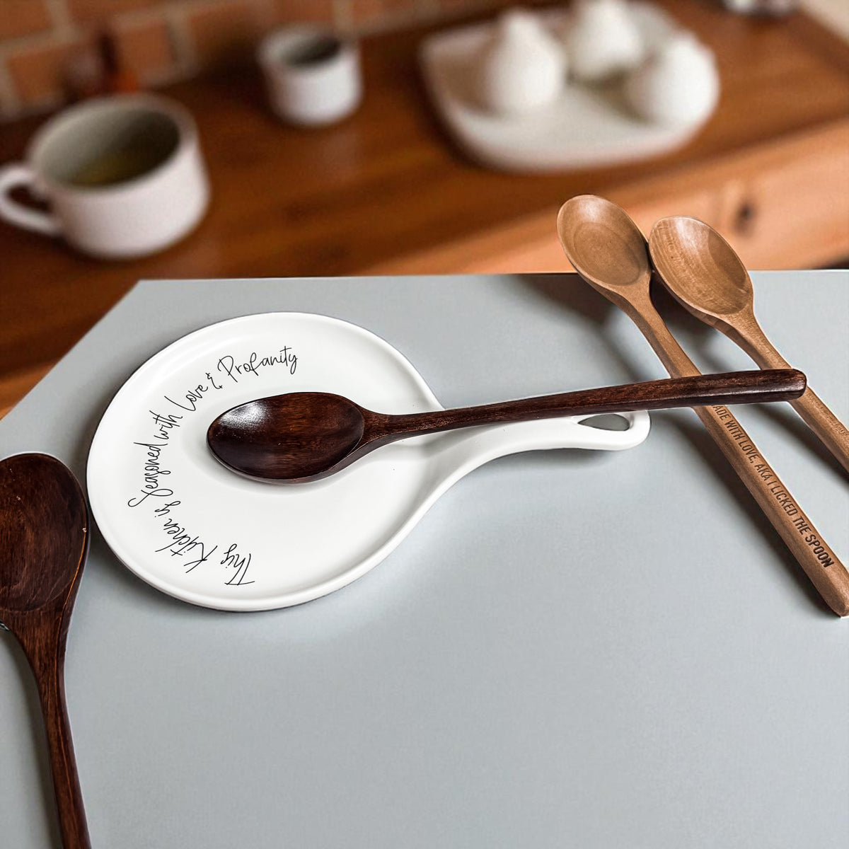 Gia Roma Love & Profanity spoon rest, white ceramic with cursive text, three wooden spoons on Tampa Home & Garden Store
