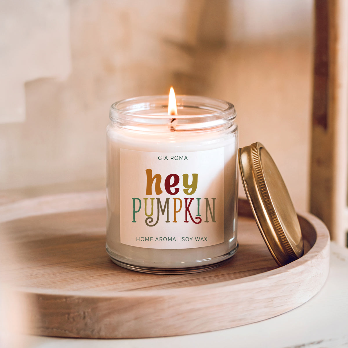 Baked Pumpkin Candle by Gia Roma in a clear glass jar with a gold lid on a wooden tray on Tampa Home & Garden Store