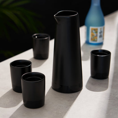 Four Black Stoneware Sake Tumblers and Carafe