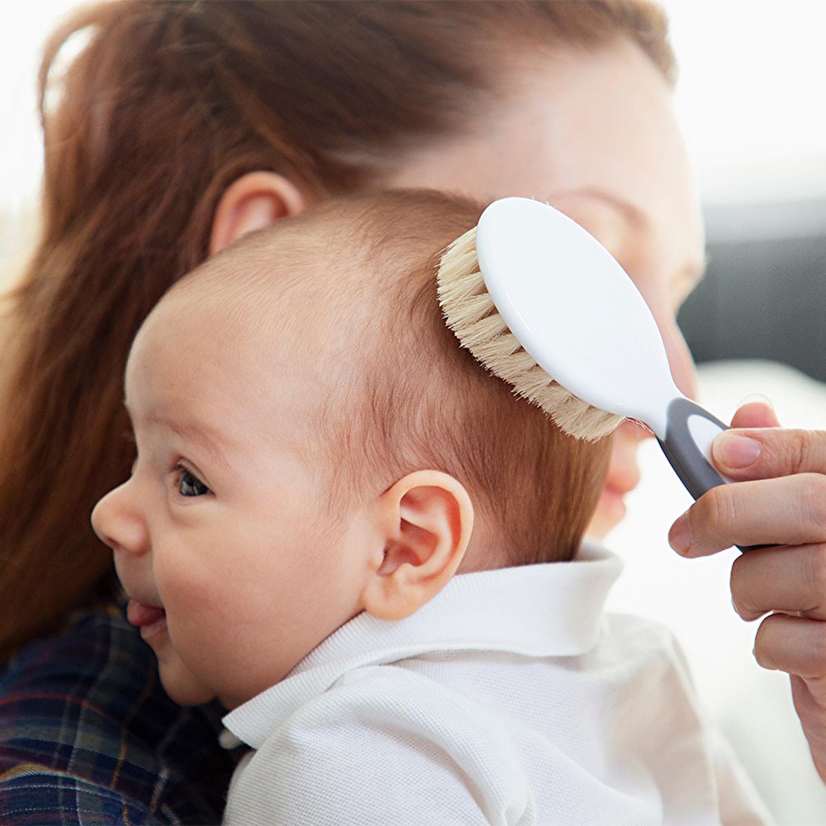 Baby grooming brush with soft beige bristles and white head, gray handle used on newborn hair on Tampa Home & Garden Store