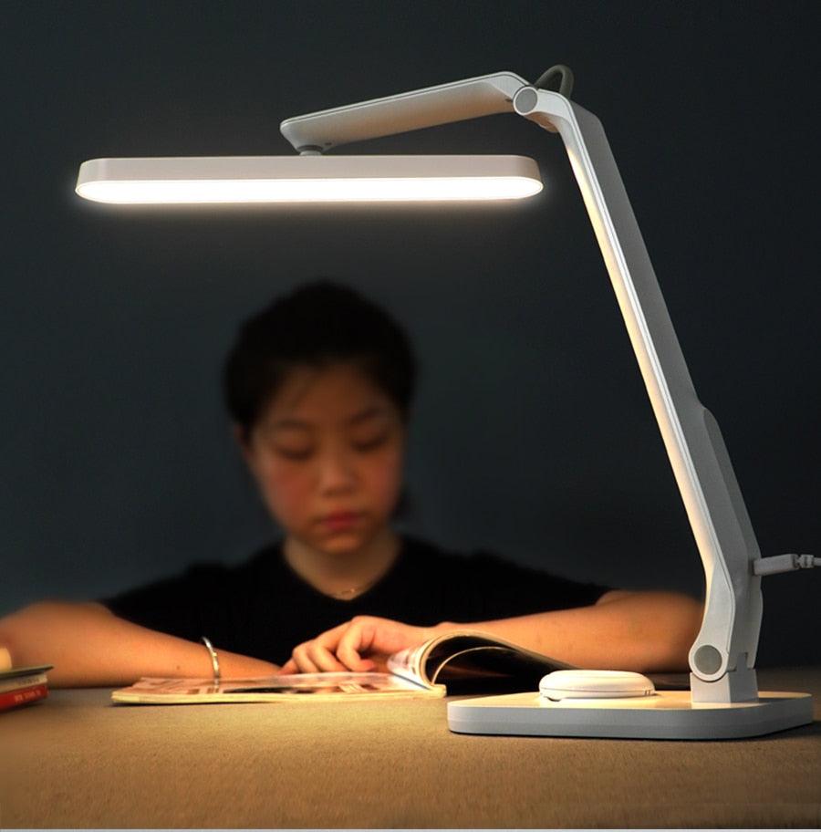 Stevvex white LED desk lamp with adjustable arm and slim bar on desk beside a book on Tampa Home & Garden Store