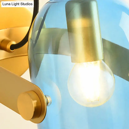 Brass cloche sconce light with blue glass shade and exposed bulb on Tampa Home & Garden Store