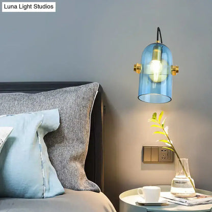 Brass cloche sconce light by Decorbites with blue glass shade, wall mounted beside bed on Tampa Home & Garden Store