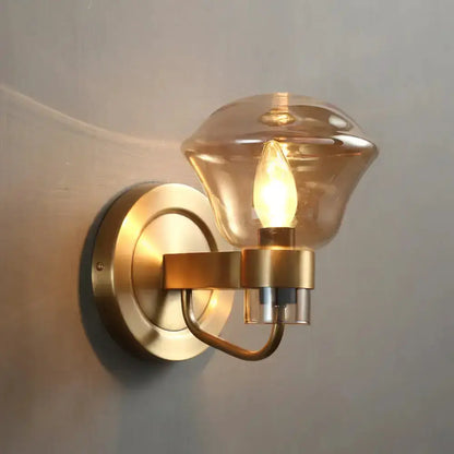 Retro brass wall sconce with smoke gray and amber glass shade, curved arm, round backplate on Tampa Home & Garden Store