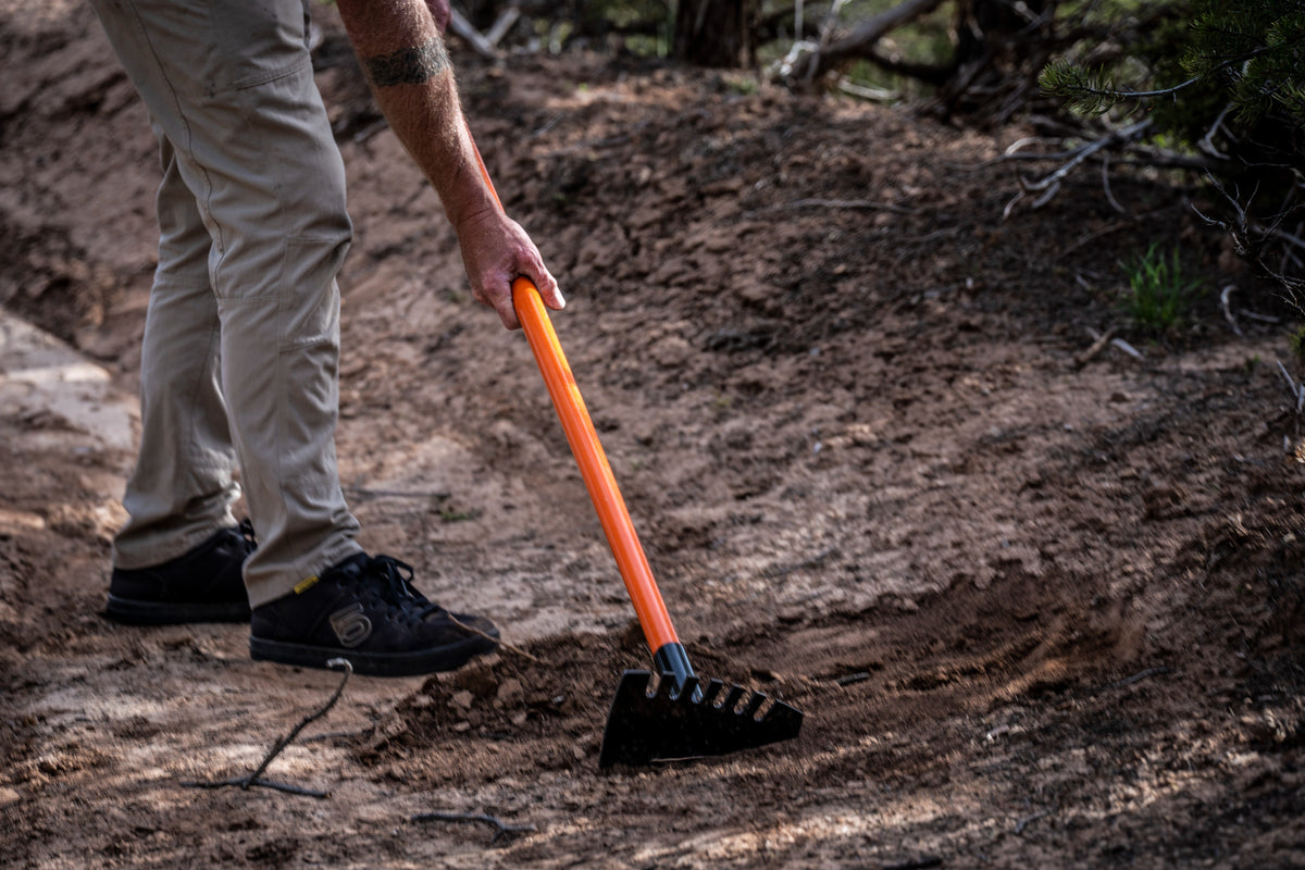 Rex orange-handled rake with black head in dirt outdoor scene on Tampa Home & Garden Store