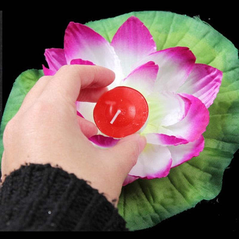 Floating lotus candle red flameless LED held over a pink-white lotus leaf by Stevvex on Tampa Home & Garden Store
