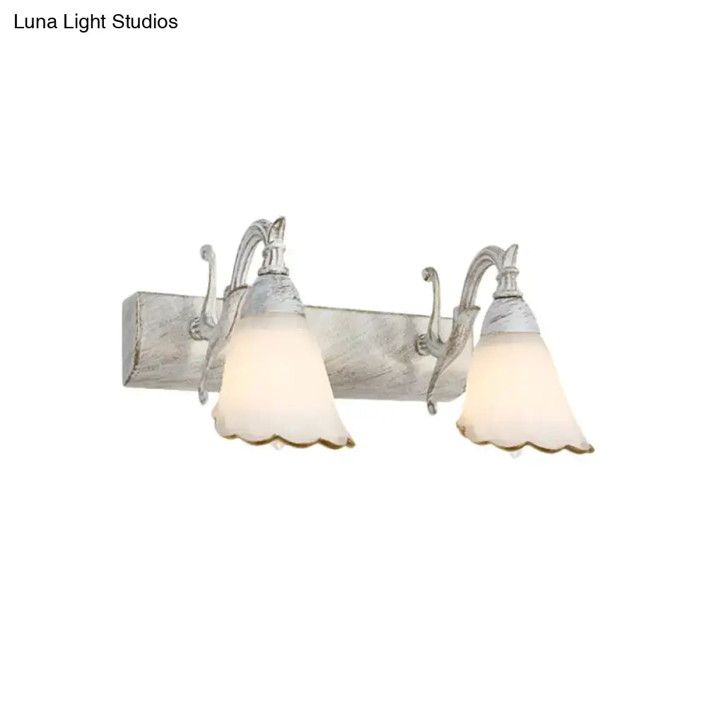 White glass vanity light by Decorbites, dual scalloped shades on rustic backplate on Tampa Home & Garden Store