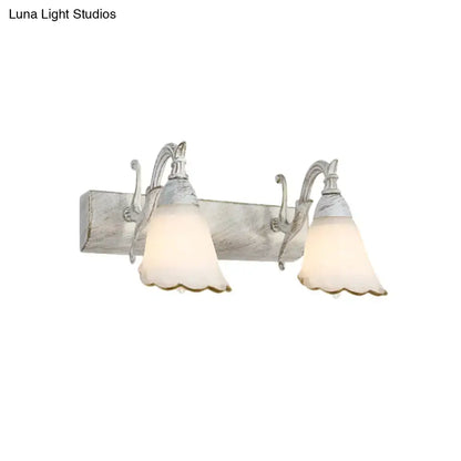White glass vanity light by Decorbites, dual scalloped shades on rustic backplate on Tampa Home & Garden Store