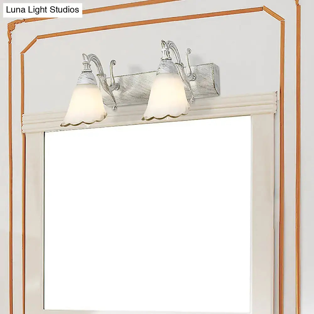 White Glass Vanity Light with dual frosted bell shades and ornate metal arms on Tampa Home & Garden Store