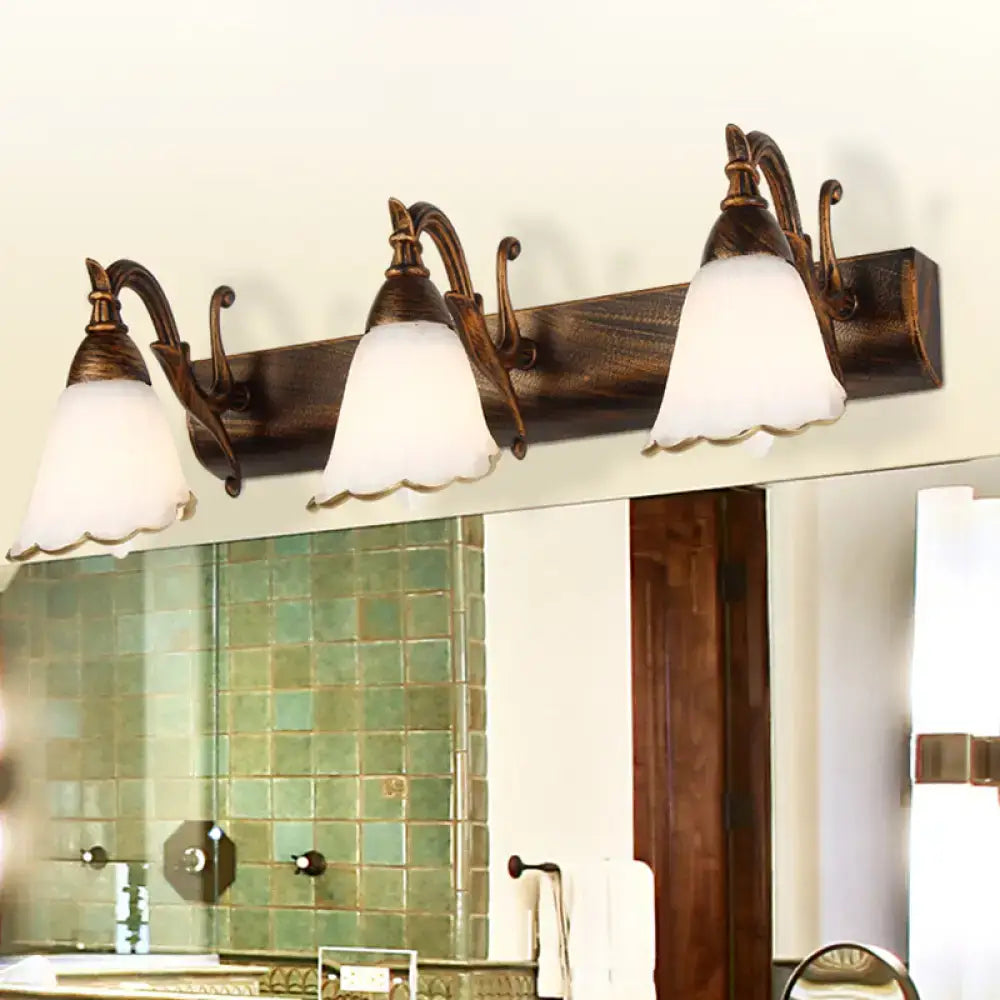 White glass vanity light with three frosted bell shades and bronze arms on Tampa Home & Garden Store